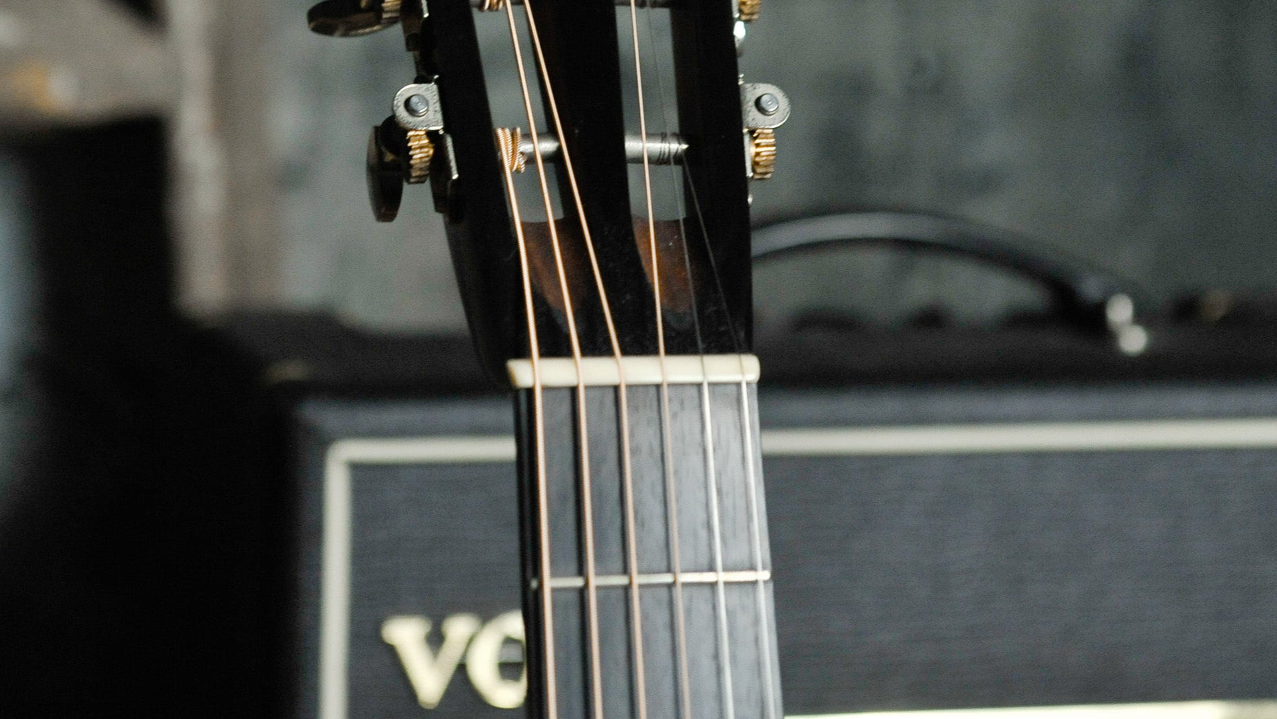 Collings guitar headstock with amplifier in the background
