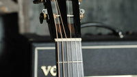 Collings guitar headstock with amplifier in the background